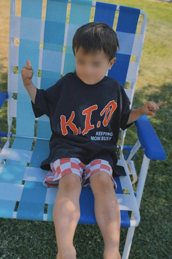 Child sitting on a blue and white chair outdoors