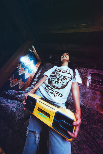 Person holding a yellow boombox in a dimly lit room
